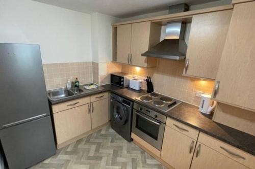 uma cozinha com um fogão, um lavatório e um frigorífico em Peebles Cardona Cozy 2 x bedroom Apartment em Cardrona Mains