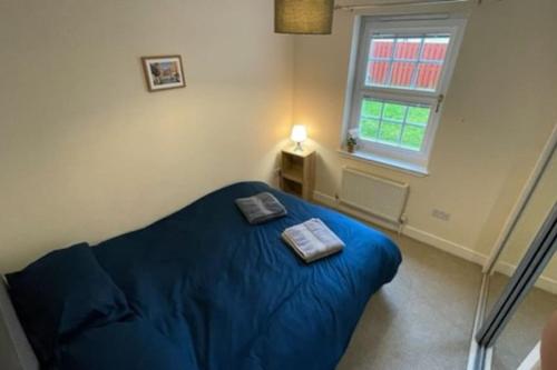 um quarto com uma cama azul e uma janela em Peebles Cardona Cozy 2 x bedroom Apartment em Cardrona Mains