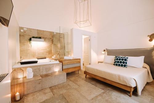 a bedroom with a tub and a bed and a sink at Suite1212 - Pirrelli in Monopoli