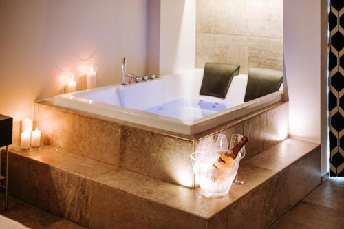 a bathroom with a tub with a bottle of champagne at Suite1212 - Pirrelli in Monopoli