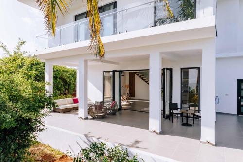 an exterior view of a white house at Safira Blu Luxury Resort & Villas in Nungwi