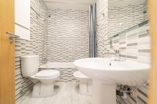 a white bathroom with a toilet and a sink at -MalagaSunApts- Stylish City Centre Pool&Parking in Málaga