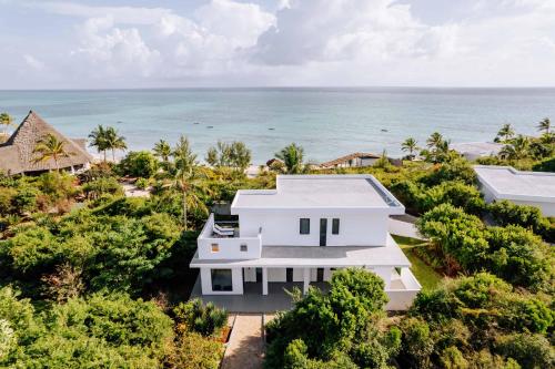 an aerial view of a white house with the ocean in the background at Safira Blu Luxury Resort & Villas in Nungwi