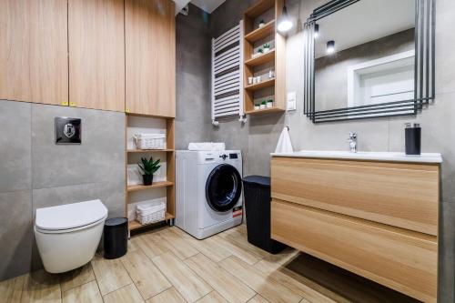 ein Badezimmer mit Waschmaschine und Waschbecken in der Unterkunft Panorama Capital Black in Rzeszów