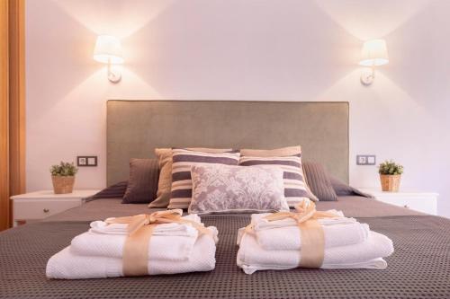a bedroom with a bed with towels on it at -MalagaSunApts- Rooftop Pool in Málaga