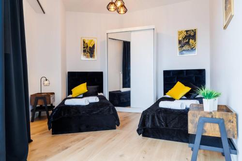 ein Schlafzimmer mit zwei Betten und einem Spiegel in der Unterkunft Panorama Capital Black in Rzeszów