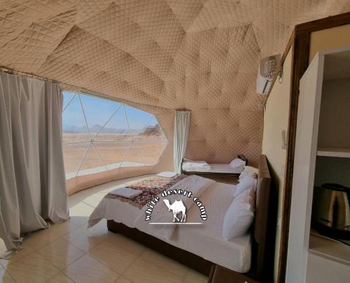 a bedroom with a bed with a view of the desert at White Desert Camp in Wadi Rum