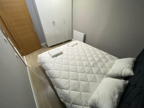 ein weißes Bett in einem Zimmer neben einer Tür in der Unterkunft Atasuit3 in Istanbul