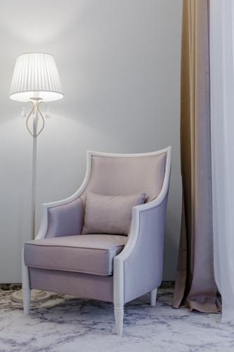 a chair in a room next to a lamp at Muller Hotel Boutique & Spa in Galaţi