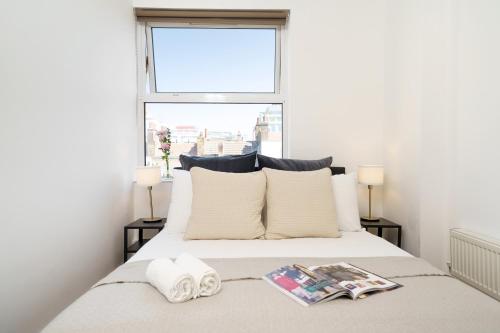 a bedroom with a white bed with a window at Best Location Oxford Str, Soho 2 Bedr, 3 Beds, 2 Bath in London