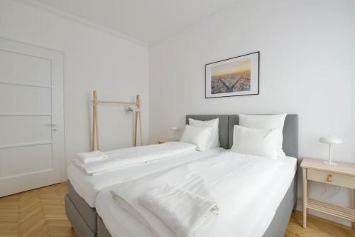 a large white bed with white sheets and pillows at Premium Apartment by Hi - Central 2 BR - best view in Budapest