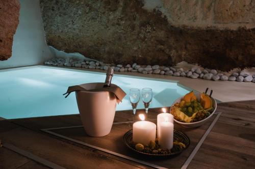 a table with candles and wine glasses next to a tub at Suite1212 - Pirrelli in Monopoli