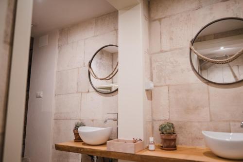 a bathroom with two sinks and two mirrors at Suite1212 - Pirrelli in Monopoli