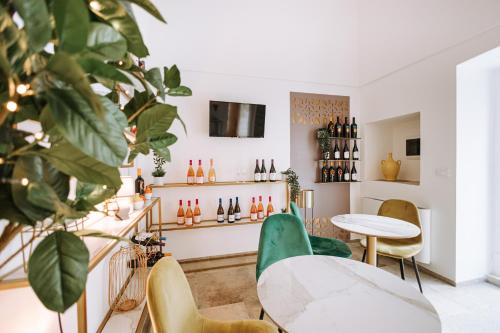 uma sala com cadeiras e mesas e uma prateleira de garrafas de vinho em Suite1212 - Pirrelli em Monopoli