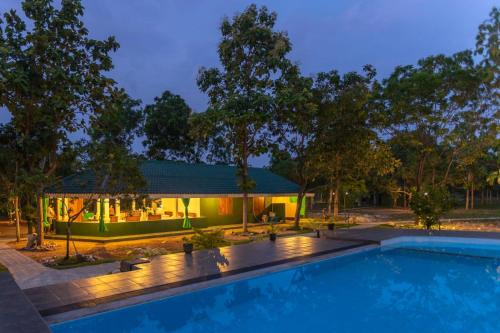a villa with a swimming pool at night at Green Nest Yala in Hambantota