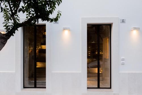 a white building with glass doors and a tree at Suite1212 - Pirrelli in Monopoli