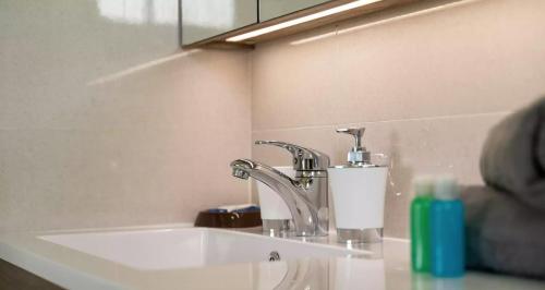 a bathroom sink with a faucet and a mirror at Cap Confort in Au Cap