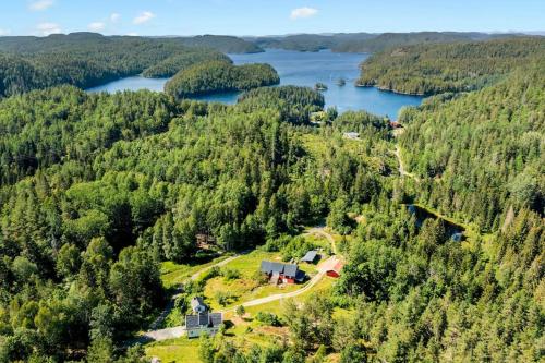 uma vista aérea de uma casa numa colina ao lado de um lago em Romantic farmhouse with idyllic garden em Bamble