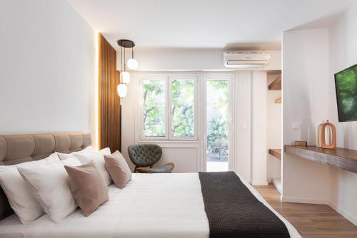 - une chambre avec un grand lit blanc et des oreillers blancs dans l'établissement Acropolis Holmes Residence, à Athènes