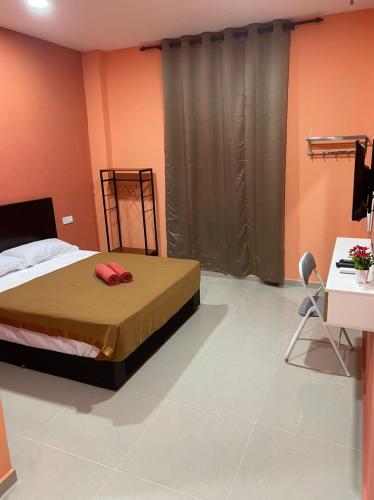 a bedroom with a bed and a desk and a desk at A&H HOUSE HOTEL in Melaka