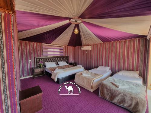 a room with three beds and a tent at White Desert Camp in Wadi Rum