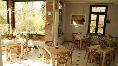 Sandau的住宿－Zum Veltenhaus，餐厅设有木桌、椅子和窗户。