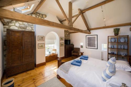 1 dormitorio con cama grande y vigas de madera en Crow House Barn en Copgrove