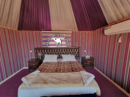 a bedroom with a bed in a room with wallpaper at White Desert Camp in Wadi Rum