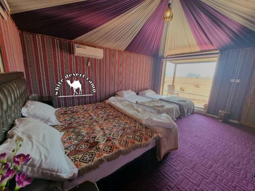two beds in a room with a tent at White Desert Camp in Wadi Rum
