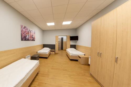 a hospital room with three beds and cabinets at Pokoje Samoobsługowe 24/7 in Kałuszyn
