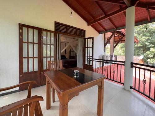a dining room with a table and a balcony at Tanzanite place in Tangalle