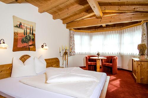 sypialnia z dużym białym łóżkiem i stołem w obiekcie Hof am Arlberg - Familie Walter w mieście Sankt Anton am Arlberg