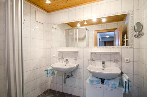 łazienka z 2 umywalkami i lustrem w obiekcie Hof am Arlberg - Familie Walter w mieście Sankt Anton am Arlberg