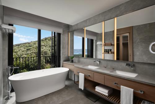 a bathroom with a tub and a large mirror at NG Enjoy in Sapanca