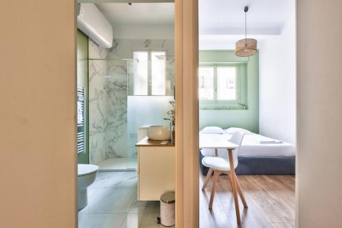 a bedroom with a bed and a table and a bathroom at Magnificent apartment - Carré d'or in Nice