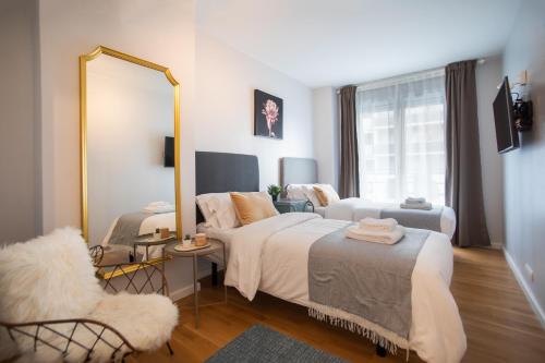 バルセロナにあるTendency Apartments Forumのベッドルーム1室(ベッド2台、鏡、椅子付)