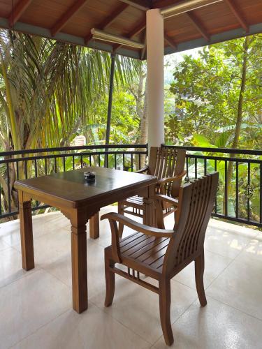 a wooden table and two chairs on a porch at Tanzanite place in Tangalle