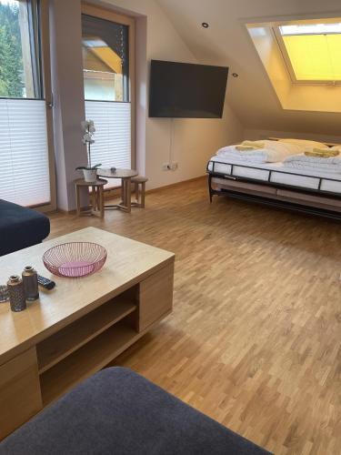 a living room with two beds and a table at Ferienwohnung Chalet Marienbrunnen in Oberstaufen
