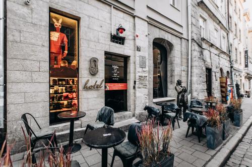uma rua com mesas e cadeiras em frente a uma loja em Masoch. Hotel & Cafe em Lviv