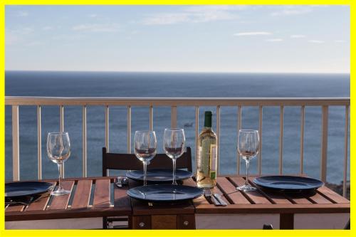 a wooden table with glasses and a bottle of wine at Lighthouse Cullera Penthouse in Cullera
