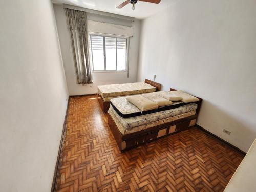 um quarto com duas camas e uma janela em Apartamento 3 quartos , vista ao mar, Pitangueiras , 8 pessoas , 50 metros do mar no Guarujá