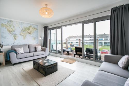 a living room with two couches and a large window at Beach Haven in Chichester