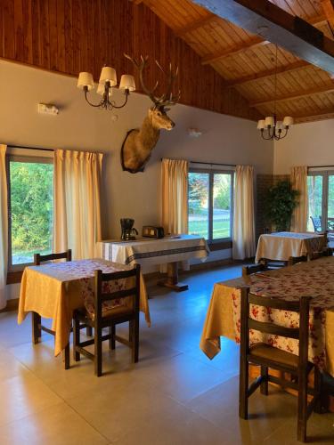 a living room with tables and a deer head on the wall at Estancia Quillen Lodge - Hosteria in Aluminé