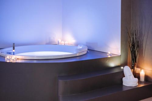 a bathroom with a tub with candles and a mirror at Suite1212 - Rattazzi in Monopoli