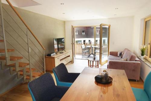 a living room with a table and chairs and a staircase at Ferienwohnung Chalet Marienbrunnen in Oberstaufen