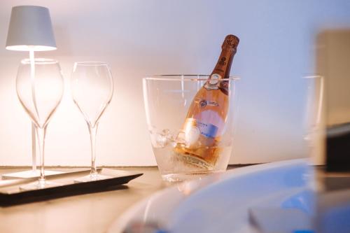 a bottle of champagne in a glass next to two wine glasses at Suite1212 - Rattazzi in Monopoli