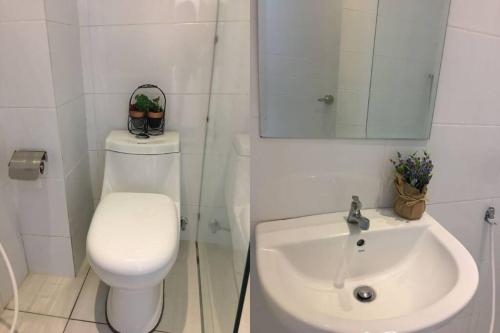 La salle de bains blanche est pourvue de toilettes et d'un lavabo. dans l'établissement CutiCuti Melaka first coise,WIFI UNIT,5min to jonker walk, à Tranquerah