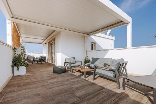 a patio with chairs and tables on a balcony at Suite1212 - Rattazzi in Monopoli