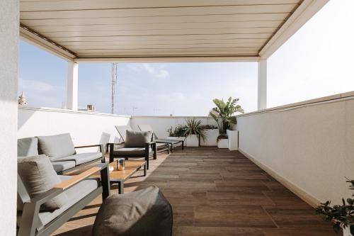 a balcony with chairs and tables on a building at Suite1212 - Rattazzi in Monopoli