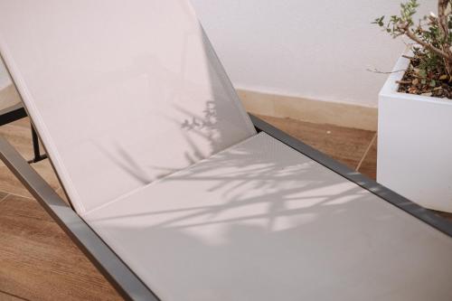 a white table with a shadow of a plant at Suite1212 - Rattazzi in Monopoli